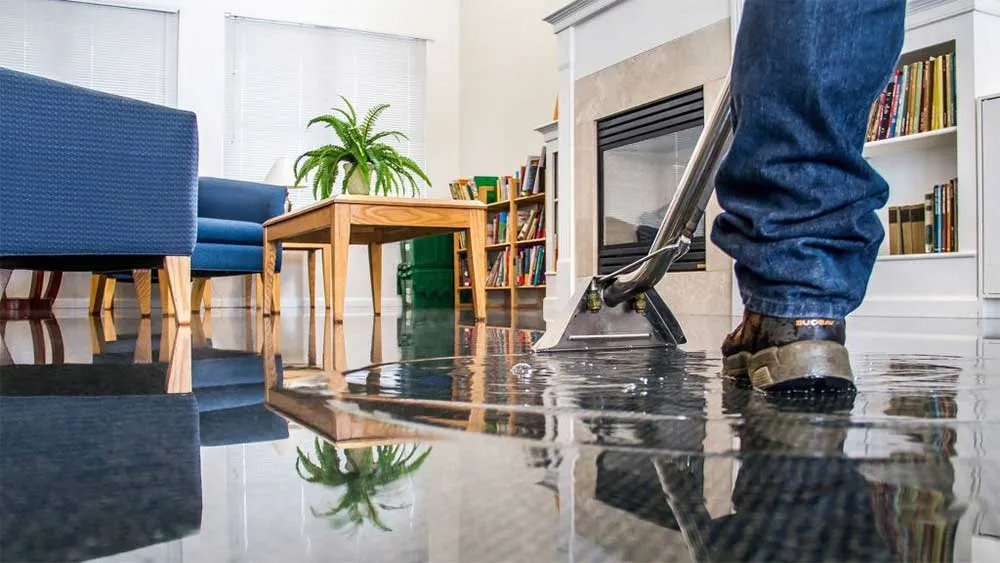 Professional emergency water damage restoration technician extracting floodwater in Canada